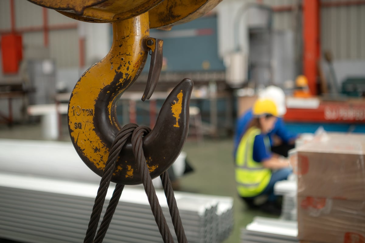Senior engineers and young female workers inspecting steel plates in a factory