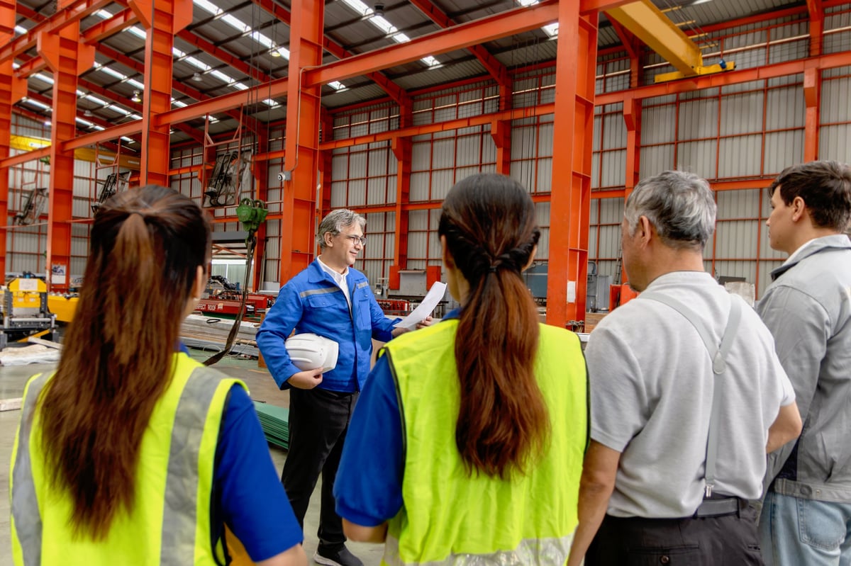 Supervisor of diverse engineers briefing his team before working in manufacturing factory.